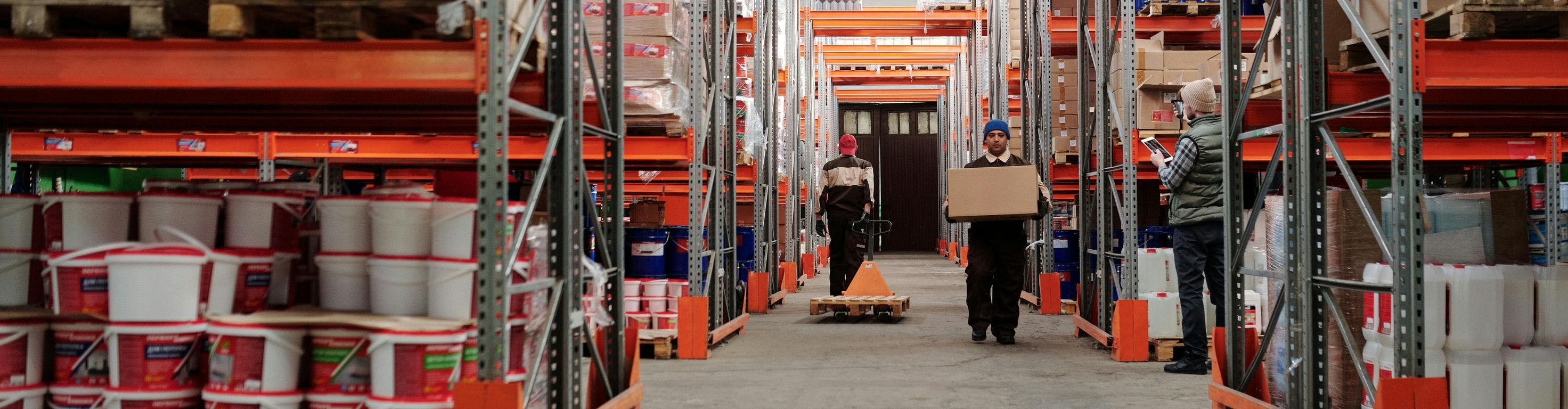 People working in the distance in an orange warehouse
