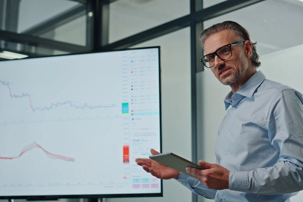 Man presenting technical charts on a screen