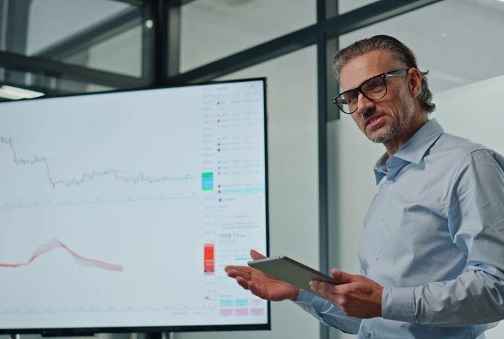 Man presenting technical charts on a screen