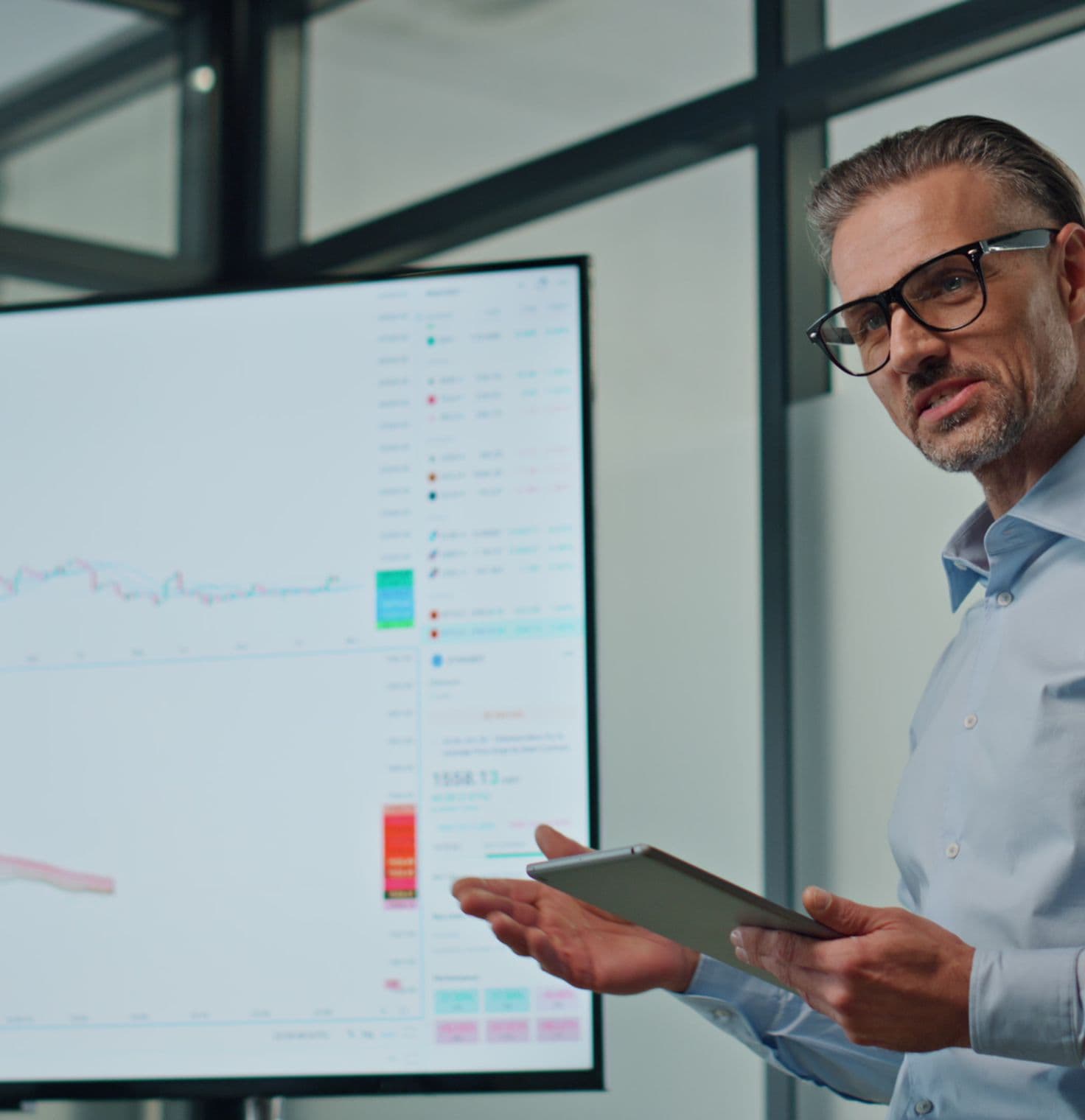 Man presenting technical charts on a screen