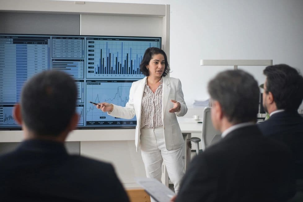 Woman presenting technical charts in a white room