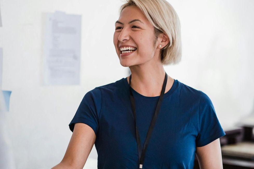 Woman with a name tag shaking hands with someone out of the frame