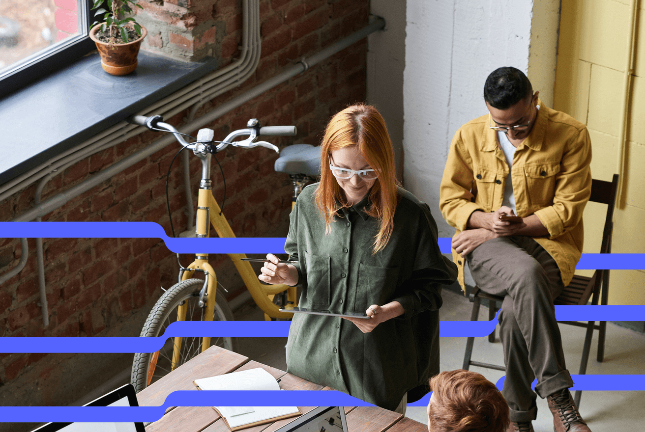 A modern office space with three people. One person holding a tablet, another works at a desk, and the third is seated on a bench looking at a smartphone. Blue lines are extending across the scene.