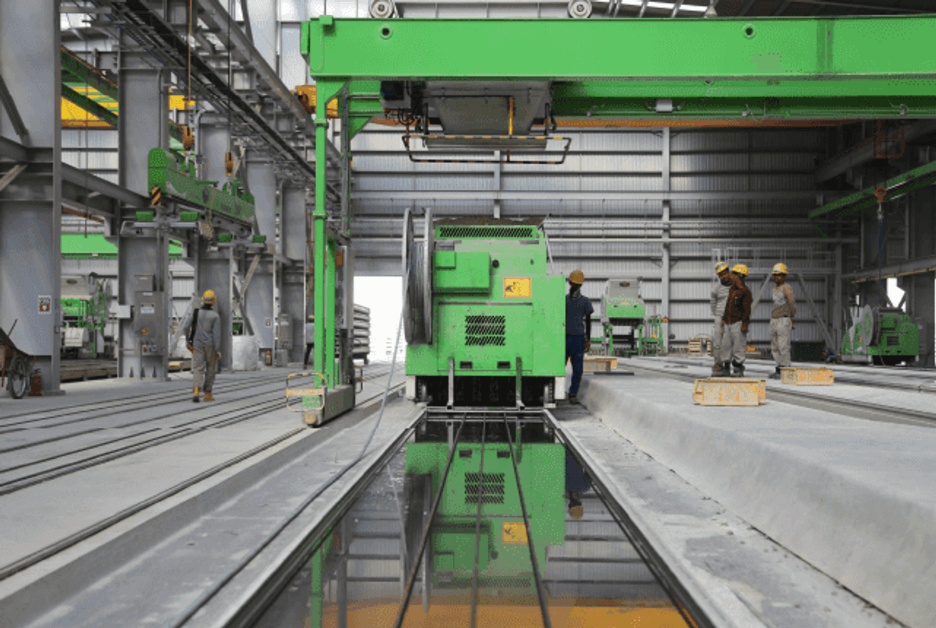 Workers in a factory using heavy equipment