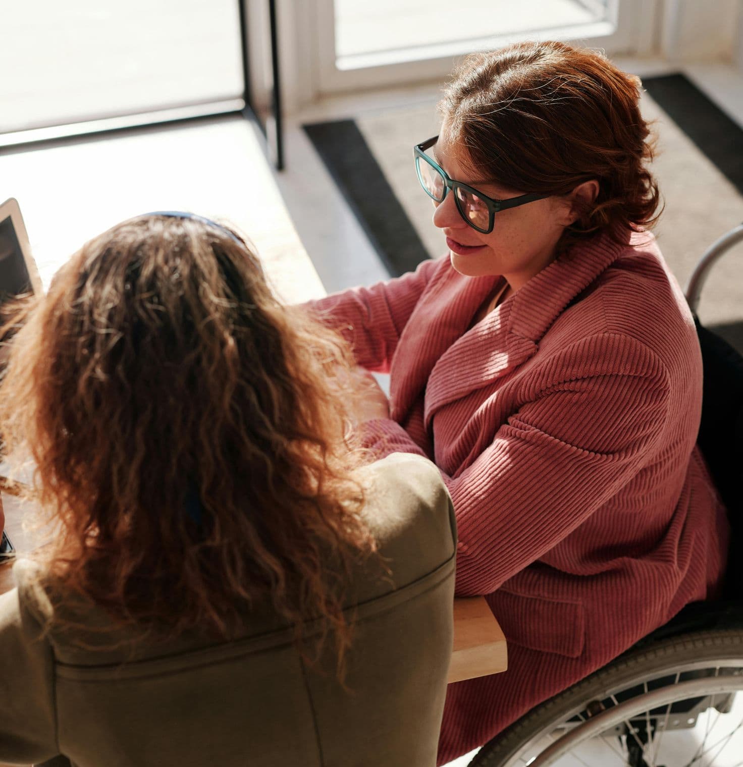 Woman in wheelchair collaborating at a computer