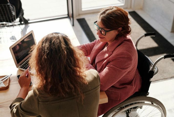 Woman in wheelchair collaborating at a computer