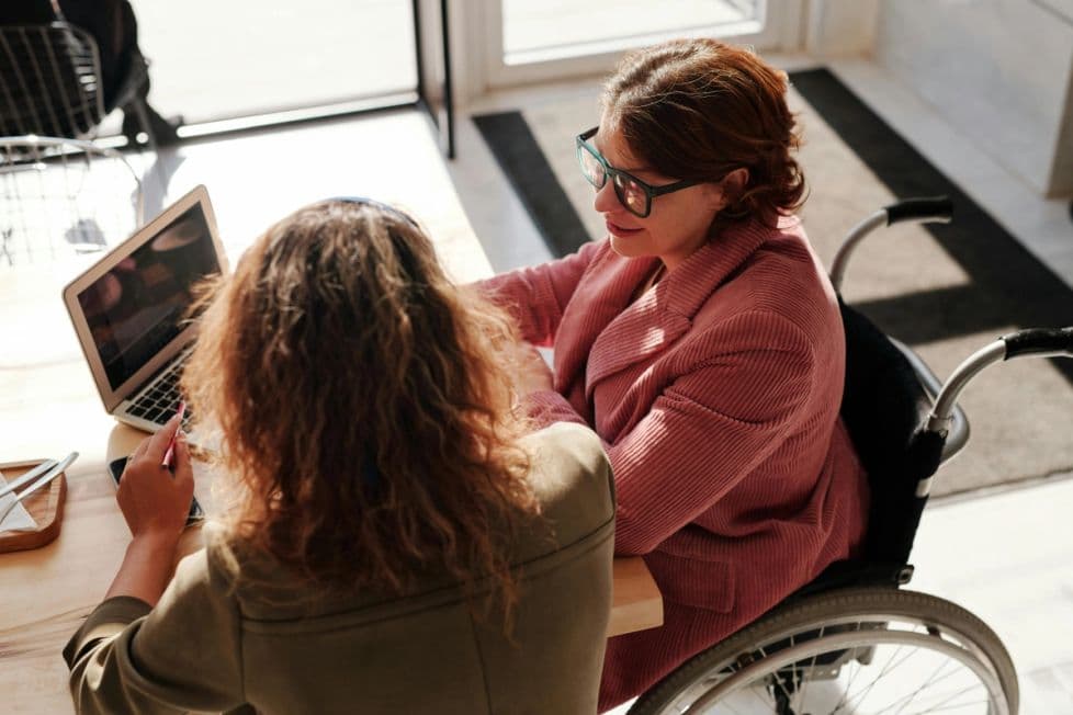 Woman in wheelchair collaborating at a computer