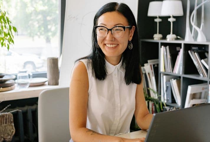 Woman working in a home office smiling at someone out of the frame