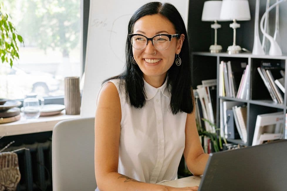 Woman working in a home office smiling at someone out of the frame