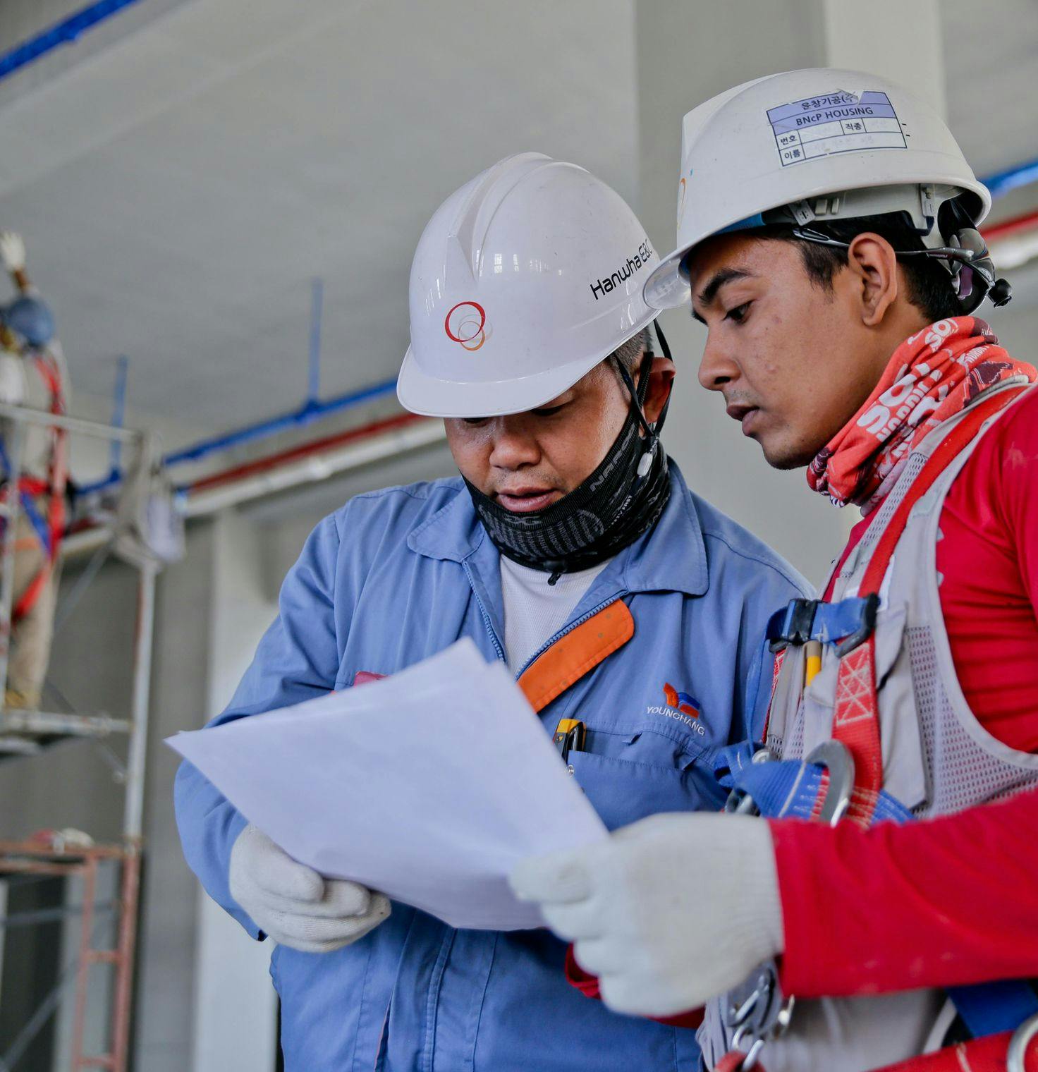 Two men reviewing paperwork on a construction site